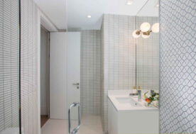 A Bathroom Design Featuring White Subway Tiles And Minimal Geometric Patterns.