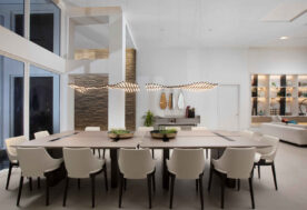 The Dining Room In A Contemporary Golden Beach Home Is Adorned With Modern Pendant Lighting.