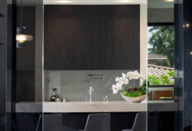 A Kitchen Design With Sliding Doors In A Woven Architecture Hallandale Beach Home.