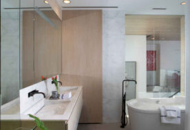 A Contemporary Oceanfront Retreat Home Featuring A  Bathroom With Double Vanities And A  Freestanding Bathtub.
