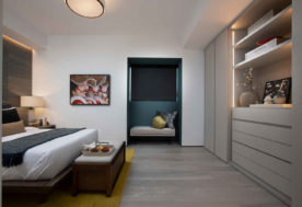 Modern Asian-inspired Penthouse Design Showcasing A Bedroom Adorned With A Window Seat And Complemented By Wall Art.