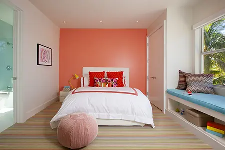A photo of a girl's bedroom design with an accent wall in pink hues