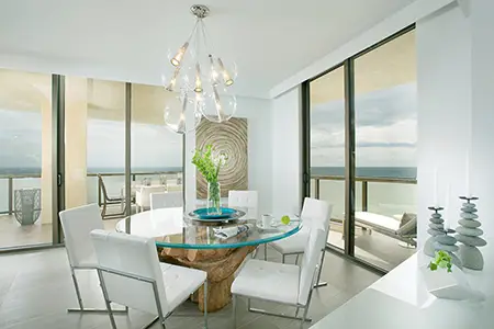 A white dining room design with a wooden circular table